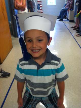 Kyser's first graduation — kindergarten cap and that same crooked grin